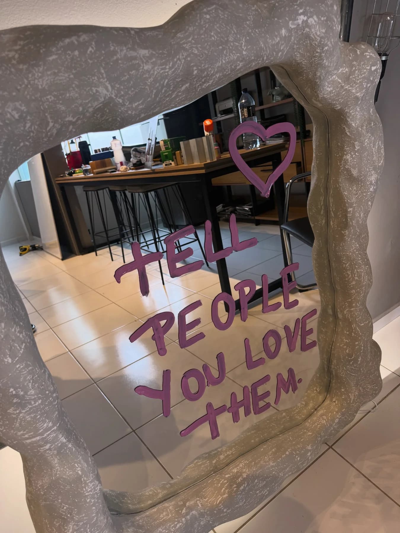 Espelho de moldura orgânica cinza com a frase tell people you love them pintada em roxo (foto 3)
