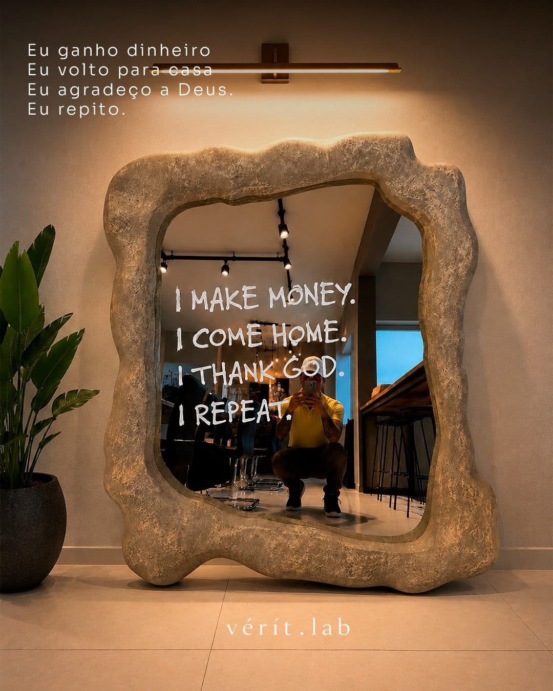 Espelho de moldura orgânica creme com frase pintada, em corredor de apartamento