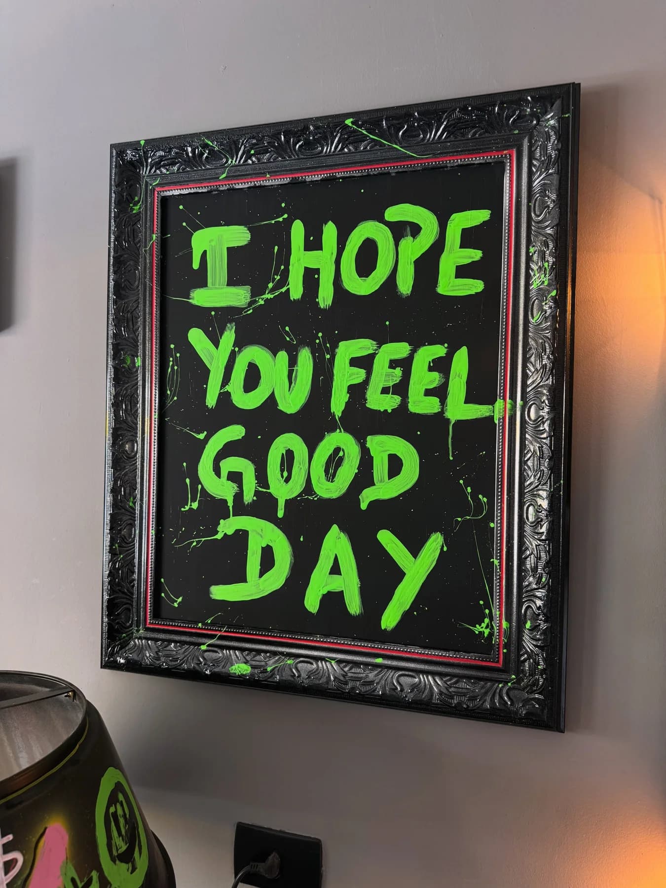 Quadro de moldura preta entalhada com fundo preto e a frase i hope you feel good day em verde neon